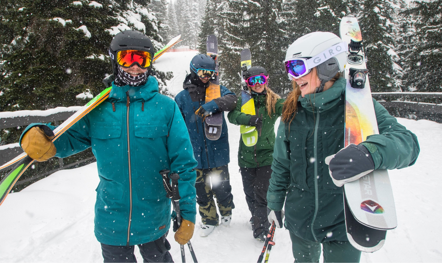 Group of skiers smiling and walking in the snow