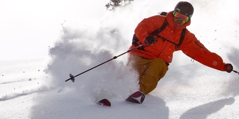 Skier skiing downhill through powdery snow